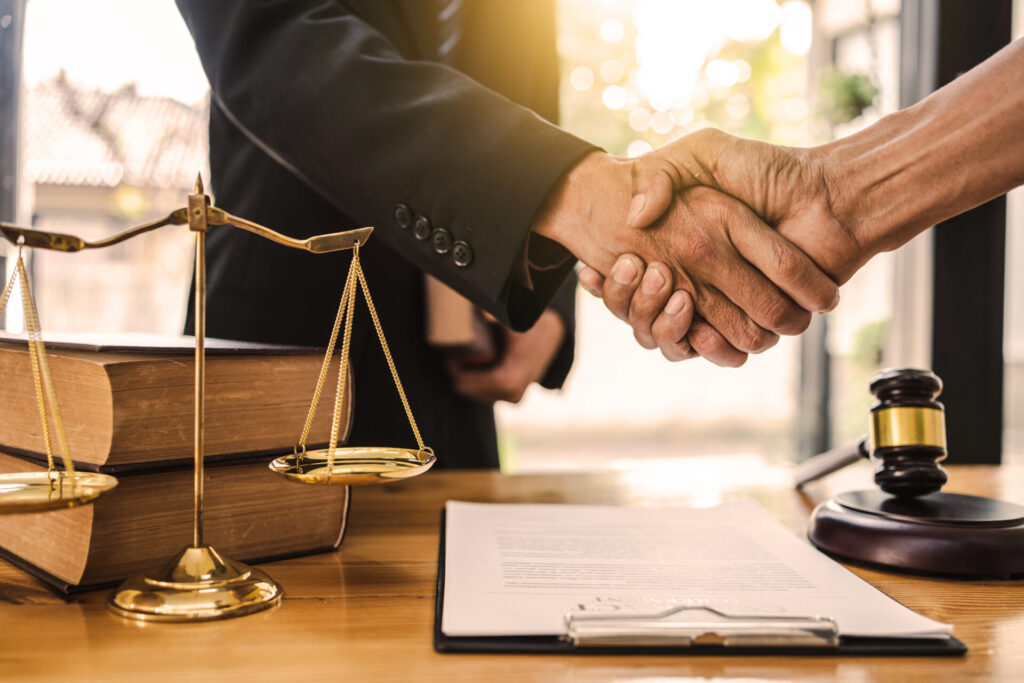 Close-up of an attorney shaking hands with a client.